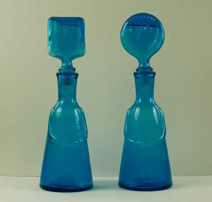 Blue glass bottles with faces on the stoppers