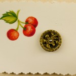 Elaborate metal button on an embellished card