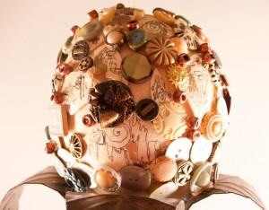 Detail of "Artifacts Egg" -  an ostrich egg embellished with buttons, beads, and pieces of ostrich shells