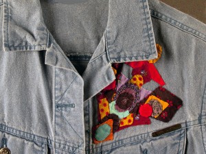 Geometric hand applique on the front of a jean vest