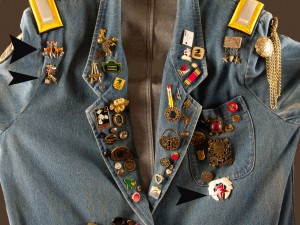 Top of jean jacket showing butons and pins