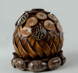Woven ball with buttons and shells glued to it
